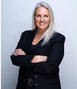 Retrato de M. Francisca Cáraves Lyng, Managing Partner y Fundadora de FIT People & Business, de brazos cruzados, con chaqueta negra sobre fondo gris claro.